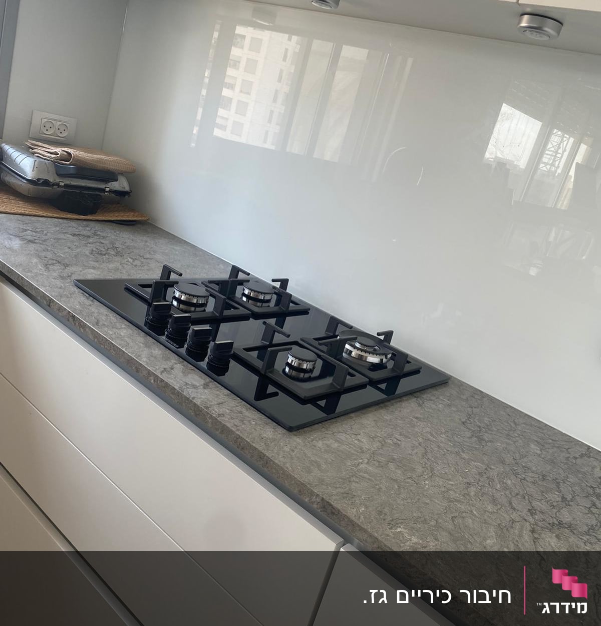 כיריים גז שחורות על משטח מטבח אפור